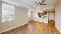 Located at 2203 N University Drive in Pembroke Pines, Florida, this 2-bedroom, 3-bathroom unit offers a well-designed, single-floor layout that maximizes functionality and comfort. The open-concept living and kitchen area serves as the heart of the home, featuring warm wood-look laminate flooring, a ceiling fan with light fixture, and natural light streaming in through multiple windows with views of the surrounding community. A sliding glass door provides additional access to the outdoors.

The kitchen is equipped with stainless steel appliances — including a refrigerator, range, microwave, and dishwasher — complemented by dark wood cabinetry, light countertops, and a pass-through breakfast bar with pendant lighting overhead.

Both bedrooms continue the wood-look flooring and neutral beige tones, each with a ceiling fan and windows that bring in natural light. The primary bedroom includes a spacious closet with bifold doors. Three bathrooms serve the unit, each finished with light tile flooring and clean, white fixtures. At least two bathrooms feature a soaking tub with white subway tile surrounds. A dedicated closet adds practical storage. The overall aesthetic is modern, clean, and move-in ready.