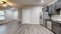 Located at 300 SW 2nd Pl in Newcastle, Oklahoma, this single-story, one-bedroom, one-bathroom home offers a well-designed layout that maximizes every square foot of its compact footprint. Wood-look tile flooring runs throughout the living areas, bedroom, and kitchen, providing a cohesive and easy-to-maintain aesthetic.

The kitchen is a standout feature, equipped with rich, dark-stained shaker-style cabinetry, dark granite countertops, a subway tile backsplash, and a full suite of stainless steel appliances including a refrigerator, range, microwave, and dishwasher. Recessed lighting adds a clean, modern touch to the space.

The bedroom is a comfortable size, featuring vaulted ceilings, a ceiling fan with light fixture, and a window that allows for natural light. A dedicated closet with dark-paneled double doors provides ample storage.

The bathroom is well-appointed with dark wood cabinetry, dark granite countertops, wood-look tile flooring, and a tiled shower/tub combination. Clean white walls and brushed nickel fixtures complete the refined look.

The attached garage features a paneled garage door with windows, an automatic opener, and a concrete floor, offering convenient and secure vehicle storage. This home presents a practical and stylish living solution in a residential Newcastle neighborhood.