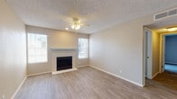 Located at 3245 E University Ave in Las Cruces, New Mexico, this single-story unit offers a practical and comfortable layout designed for everyday living. The living room serves as the centerpiece of the home, featuring a classic fireplace framed by a simple mantel, light wood-look luxury vinyl flooring, a ceiling fan with integrated lighting, and multiple windows that invite natural light throughout. Neutral-toned walls and a textured ceiling carry throughout the space, creating a cohesive and understated aesthetic. Adjacent to the living area, the galley-style kitchen is efficiently designed with white shaker cabinetry, clean white countertops, a double-basin sink, and stainless steel appliances including a gas range and refrigerator. The layout allows for a seamless transition between the kitchen and the main living and dining areas. The bedrooms are carpeted for comfort, each featuring neutral walls, windows with blinds, and ample closet space, including a sliding-door closet with built-in shelving in one room. The bathroom is well-appointed with a white vanity featuring raised-panel cabinetry, a full tub and shower combination, and wood-look flooring that ties the space together. Overall, the unit presents a clean, move-in-ready interior with functional finishes throughout.