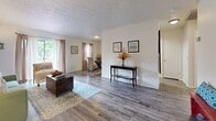 Located at 5751 Kingfish Dr in Lutz, Florida, this single-story home offers a well-organized layout with a warm, comfortable aesthetic throughout. The open-concept living and dining area is one of the home's standout features, showcasing durable wood-look plank flooring, neutral walls, and multiple windows dressed with sheer curtains that invite natural light to fill the space generously. The living area provides ample room for seating arrangements and flows seamlessly into the dining space, creating an ideal setting for both relaxing and entertaining.

The galley-style kitchen is efficiently designed with light wood cabinetry lining both sides, offering abundant storage and counter space. It is equipped with a full suite of appliances, including a refrigerator, dishwasher, and range, complemented by a double-basin sink and wood-toned laminate countertops. Wood-look flooring continues through the kitchen, maintaining a cohesive look.

The bedroom features plush carpeting, a textured ceiling, and a window that allows natural light in, creating a restful atmosphere. A closet provides convenient built-in storage. The bathroom includes an extended white vanity with a large mirror, providing generous counter space, alongside a tub-shower combination. Throughout, the home maintains a consistent, neutral palette that offers a clean and inviting ambiance.