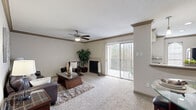 Located in Seabrook, TX, this thoughtfully designed one-bedroom, one-bathroom residence offers a comfortable and cohesive living experience across a single floor. The open-concept living room is anchored by a tiled fireplace and bathed in natural light through sliding glass doors that lead to a balcony with outdoor views. Crown molding, a ceiling fan, and plush carpeting add warmth and character to the space.

The galley-style kitchen is well-equipped with dark espresso cabinetry, granite-look countertops, tile backsplash, and stainless steel appliances. A pass-through window connects the kitchen to the living area, enhancing the open flow of the layout. Pendant lighting above the pass-through adds a stylish finishing touch.

The generously sized bedroom features soft carpet, a ceiling fan, and a large window that fills the room with natural light. A dedicated closet provides practical storage. The bathroom offers a granite-topped vanity with dark cabinetry, tile flooring, and a separate water closet for added privacy.

Throughout the residence, consistent finishes including neutral tones, crown molding, and tile flooring in wet areas create a cohesive and inviting atmosphere well-suited for comfortable everyday living.