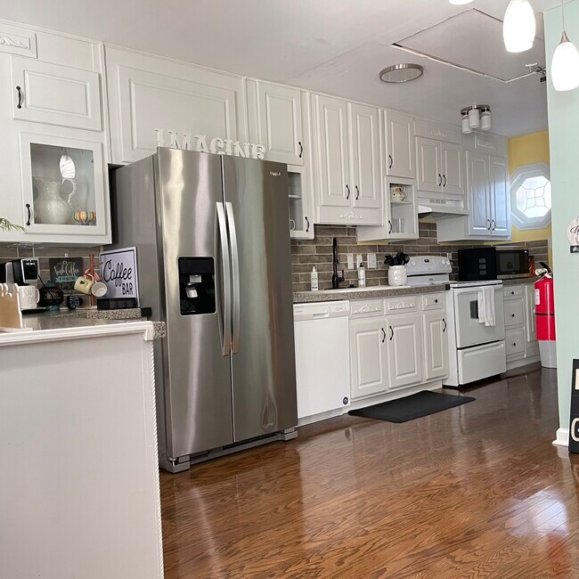 A cozy, modern kitchen featuring granite countertops, stainless steel refrigerator, perfect for cook - 2171 Weatherstone Cir SE