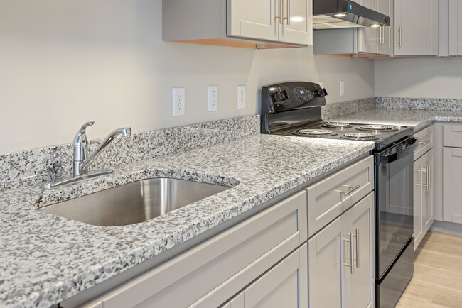 Estilo 1A Cocina con encimeras de granito - Homes at Oxon Hill Senior 62+ Apartments