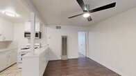 Located at 3132 3rd Ave in Sacramento, CA, this efficient one-bedroom, one-bathroom residence offers a well-organized single-floor layout designed to maximize every square foot. The open-concept living, dining, and kitchen area forms the heart of the home, where rich dark hardwood-style flooring flows seamlessly through the living and dining spaces, transitioning to classic light tile in the kitchen. A ceiling fan with integrated lighting keeps the area comfortable and well-lit, while large windows dressed with horizontal blinds allow natural light to fill the room. Built-in shelving adds practical storage and visual interest near the entryway. The kitchen is appointed with white cabinetry, a gas range, over-the-range microwave, and a full-size refrigerator, all set against clean white countertops and tile flooring. A partial dividing wall with additional cabinetry neatly separates the kitchen from the living area. The bedroom offers a quiet retreat with light wood-style flooring, a ceiling fan, and access to two closets, providing ample storage. The bathroom features a full tub-shower combination with white tile surround and chrome fixtures, maintaining the clean, bright aesthetic found throughout the home. Overall, the space presents a crisp, white-toned palette with practical finishes suited for comfortable everyday living.