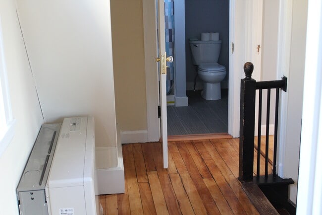 Upstairs hallway, looking toward the bathroom &amp; bedroom #2. New monitor heater. - 1011 Main St