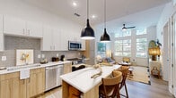 Located at 600 St Albans Dr in Raleigh, NC, this thoughtfully designed one-bedroom, one-bathroom residence offers a modern open-concept layout across a single floor. The combined living, dining, and kitchen area forms the heart of the home, characterized by soaring ceilings and an abundance of natural light pouring through large, floor-to-ceiling windows that frame outdoor views of lush greenery and the surrounding neighborhood.

The kitchen is outfitted with stainless steel appliances, a full-size refrigerator, gas range, built-in microwave, and dishwasher. Light wood cabinetry pairs with crisp white upper cabinets and a neutral tile backsplash, while quartz countertops and a peninsula with seating provide both functionality and style. Pendant lighting adds a refined finishing touch above the dining area.

The living room is bright and airy, benefiting from the dramatic ceiling height and expansive windows that fill the space with natural light. The bedroom is a comfortable retreat featuring tall ceilings, large windows with outdoor views, and access to a well-sized closet. The bathroom is clean and modern, appointed with wood-toned cabinetry, a white tile walk-in shower with glass enclosure, and wood-look flooring. The unit also includes a dedicated laundry area, utility room, and two closets for ample storage.