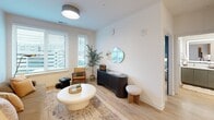 Located in the heart of downtown Raleigh at 222 N West St, this well-appointed one-bedroom, one-bathroom residence offers a thoughtfully designed single-floor layout with modern finishes throughout. Light wood-tone flooring flows seamlessly across the open-concept living and kitchen areas, creating a warm, cohesive aesthetic.

The kitchen is a standout feature, showcasing two-tone cabinetry with sage green lower cabinets and natural wood upper cabinets paired with open shelving. A large white waterfall island anchors the space, illuminated by stylish globe pendant lights. Stainless steel appliances, white subway tile backsplash, and recessed lighting complete the contemporary look.

The living room benefits from multiple windows that invite abundant natural light and offer urban city views. The space feels open and airy, with clean white walls that complement the warm flooring.

The bedroom is distinguished by rich teal accent walls, large windows with city views, and a ceiling fan. Two closets provide ample storage.

The bathroom features a long vanity with sage green cabinetry, a backlit mirror, and a full tub-shower combination with white subway tile. Additional conveniences include in-unit laundry and a utility room, making this a fully functional and stylish downtown residence.
