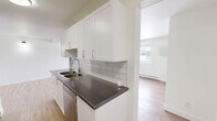 Located at 2620 Sycamore Dr in Windsor, Ontario, this well-appointed one-bedroom, one-bathroom unit offers a thoughtfully designed layout spread across a single floor. Light hardwood-style flooring runs throughout the living areas and bedroom, creating a warm, cohesive aesthetic.

The galley-style kitchen is a standout feature, finished with crisp white shaker cabinetry, dark granite-style countertops, and a classic white subway tile backsplash. Stainless steel appliances, including a refrigerator, stove, and dishwasher, are integrated seamlessly into the design, and a double stainless steel sink adds practicality.

The open-concept living and dining area is bright and inviting, with multiple windows that bring in natural light and offer views of the surrounding neighbourhood. Baseboard heating units are present throughout, ensuring comfort year-round.

The bedroom is a comfortable size, featuring dual closets with bifold doors, providing ample storage. Neutral white walls throughout the unit create a clean, versatile canvas.

The bathroom is finished with grey tile flooring, a dark vanity with a light stone-style countertop, and a clean, modern aesthetic. This unit combines functional design with modern finishes for comfortable everyday living.