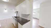 Located at 2620 Sycamore Dr in Windsor, Ontario, this well-appointed one-bedroom, one-bathroom unit offers a thoughtfully designed layout spread across a single floor. Light hardwood-style flooring runs throughout the living areas and bedroom, creating a warm, cohesive aesthetic.

The galley-style kitchen is a standout feature, finished with crisp white shaker cabinetry, dark granite-style countertops, and a classic white subway tile backsplash. Stainless steel appliances, including a refrigerator, stove, and dishwasher, are integrated seamlessly into the design, and a double stainless steel sink adds practicality.

The open-concept living and dining area is bright and inviting, with multiple windows that bring in natural light and offer views of the surrounding neighbourhood. Baseboard heating units are present throughout, ensuring comfort year-round.

The bedroom is a comfortable size, featuring dual closets with bifold doors, providing ample storage. Neutral white walls throughout the unit create a clean, versatile canvas.

The bathroom is finished with grey tile flooring, a dark vanity with a light stone-style countertop, and a clean, modern aesthetic. This unit combines functional design with modern finishes for comfortable everyday living.