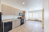 Located at 1621 E 120th Ave in Northglenn, Colorado, this thoughtfully designed one-bedroom, one-bathroom unit makes excellent use of its compact footprint across a single floor. Light-toned wood-look flooring runs throughout, creating a cohesive and easy-to-maintain aesthetic in every room.

The kitchen is outfitted with light wood cabinetry extending to the ceiling for ample storage, granite-style countertops, and a full suite of black appliances including a refrigerator, electric range, over-the-range microwave, and dishwasher. The kitchen opens directly into the living area, which is anchored by a large multi-pane window that fills the space with natural light and offers views of the surrounding neighborhood. A wall-unit HVAC system provides climate control.

The bedroom is a clean, well-proportioned space featuring warm wood-look flooring, a sliding closet, and a ceiling fan for additional comfort. The bathroom offers a wood-toned vanity with granite-style countertop, a mirror, and wood-look tile flooring. A dedicated laundry room houses a full-size front-loading washer and dryer set with wire shelving above, adding significant everyday convenience. The unit presents a modern, move-in-ready interior with a neutral palette throughout.