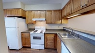 Located at 450 Johnny Mercer Blvd in Savannah, Georgia, this single-floor space offers a practical and well-appointed layout. The kitchen is a standout feature, showcasing warm honey-toned wood cabinetry that extends from floor to ceiling, providing generous storage throughout. Dark countertops offer a subtle contrast to the cabinetry, while a stainless steel double-basin sink adds a functional touch. The kitchen is equipped with a white electric range and oven, an overhead ventilation hood, and a dishwasher, making it fully outfitted for everyday use. The flooring transitions to rich hardwood tones, adding warmth to the space. A textured ceiling runs throughout, contributing to the classic character of the interior. The overall ambiance is practical and comfortable, with a traditional aesthetic defined by natural wood tones and neutral finishes. Situated in the Savannah, GA area, this space benefits from its coastal Georgia location near the Wilmington Island community, offering convenient access to local amenities, waterways, and the charm of the greater Savannah region.