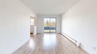 Located at 350 Erb St W in Waterloo, Ontario, this well-appointed 2-bedroom, 1-bathroom unit offers a functional and bright single-floor layout. Light-toned hardwood-style flooring flows consistently throughout, creating a clean, cohesive aesthetic. The galley-style kitchen is thoughtfully designed with white shaker cabinetry, subway tile backsplash, stainless steel appliances including a refrigerator, electric range, over-the-range microwave, and dishwasher, along with a built-in pantry closet for added storage. Adjacent to the kitchen, the dining area benefits from a large window that brings in natural light and outdoor views. The spacious living room is a highlight, featuring sliding glass doors that open directly onto a private balcony overlooking green communal grounds and the surrounding neighbourhood. The bathroom is finished with classic white subway tile surrounding a full soaker tub and includes a window for natural ventilation. Both bedrooms are comfortably sized with large windows, hardwood-style flooring, baseboard heating, and generous closet storage. The unit also features a dedicated entrance hallway and four closets total, ensuring ample storage throughout.
