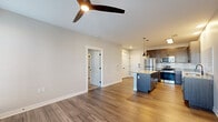 Located at 451 N Lebanon St in Lebanon, Indiana, this well-appointed one-bedroom, one-bathroom unit offers a thoughtfully designed open-concept layout. The combined kitchen and living area serves as the heart of the home, showcasing warm wood-tone luxury vinyl plank flooring, a modern ceiling fan, and a seamless flow between spaces. The kitchen is a standout feature, equipped with dark espresso cabinetry, granite countertops, a classic white subway tile backsplash, stainless steel appliances including a refrigerator, range, microwave, and dishwasher, and a central island with pendant lighting — ideal for both meal preparation and casual dining. The spacious bedroom is finished with plush carpet, a ceiling fan, and access to a dedicated closet, providing comfortable and practical accommodations. A private exterior door with sidelight window allows natural light to filter into the bedroom area. The bathroom features coordinating dark cabinetry with a granite vanity top, wood-look flooring, and a full tub-shower combination. Neutral tones and clean lines throughout create a cohesive, modern aesthetic, while consistent finishes tie each room together into a polished, move-in-ready living space.