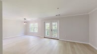 Located at 116 Danbury Rd in Wilton, CT, this thoughtfully designed three-floor townhouse offers 2 bedrooms and 3 bathrooms with a clean, contemporary aesthetic throughout. The ground floor features an attached garage with an automatic door, providing convenient covered parking and additional storage. The main living level serves as the heart of the home, showcasing a bright, open-concept layout with light hardwood flooring, crown molding, and neutral tones. The kitchen is a standout feature, appointed with crisp white cabinetry, subway tile backsplash, stainless steel appliances, recessed lighting, and matte black hardware accents. The adjacent living area is anchored by elegant French doors that open onto a private balcony, offering serene, unobstructed views of surrounding mature trees. The upper floor is home to two well-proportioned bedrooms, each filled with natural light from large windows framing lush greenery. The primary bedroom features vaulted ceilings and a spacious closet. The three bathrooms are finished to a high standard, with one showcasing marble-look tile flooring, a tub-shower combination with white subway tile surround, and a sleek sliding glass door with matte black fixtures. Clean lines, bright interiors, and wooded views give this townhouse a fresh, move-in-ready appeal.