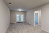 Located at 2308 Holiday Loop in Reidsville, NC, this single-floor, one-bedroom, one-bathroom home offers a well-designed layout with modern finishes throughout. The open-concept living area combines the living room, dining room, and kitchen into one cohesive space, finished with light hardwood-style flooring. The kitchen is a standout feature, equipped with crisp white shaker cabinets, granite countertops, stainless steel appliances including a range, microwave, dishwasher, and refrigerator, and a peninsula that provides additional counter and seating space. The living room is carpeted and filled with natural light, offering direct access to a private patio through a set of glass French doors. The generously sized bedroom features plush carpet, a ceiling fan, and a large window that brings in ample natural light, along with two closets for storage. The bathroom is finished with granite countertops, a single vanity sink, and light hardwood-style flooring that complements the overall aesthetic. A dedicated laundry area and hallway round out the functional layout. Neutral wall tones and clean lines throughout give the home a fresh, move-in-ready feel.