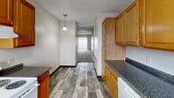 Located at 2725 S Emporia St in Wichita, Kansas, this two-bedroom, two-bathroom unit offers a practical and comfortable single-floor layout. The kitchen is well-appointed with warm honey-toned wood cabinetry, dark granite-style countertops, and white appliances including a range, refrigerator, and dishwasher. Wood-look plank flooring runs through the kitchen and extends into the hallway, while a pendant light adds a touch of character. The hallway connects the kitchen to the living areas, with vertical blinds at the far end allowing natural light to filter through.

Both bedrooms feature neutral-toned carpet and textured ceilings, creating a cozy atmosphere. The primary bedroom is notably spacious and includes direct access to one of the two bathrooms, as well as a dedicated closet. The second bedroom is well-sized with a window that brings in natural light. A sliding-door closet in the additional bedroom provides convenient storage. Both bathrooms are finished with wood-look flooring and include full tub/shower combinations with clean white surrounds. The overall color palette throughout is neutral and understated, offering a blank canvas for personalization.