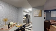 Located at 4610 N Armenia Ave in Tampa, FL, this thoughtfully designed single-floor residence offers a cohesive blend of modern updates and functional living spaces. The galley-style kitchen is a standout feature, showcasing two-tone grey and white cabinetry, marble-look countertops, stainless steel appliances, and light wood-look flooring — creating a clean and contemporary aesthetic. Adjacent to the kitchen, the dining area is defined by a textured accent wall, flush ceiling lighting, and an intimate layout ideal for everyday meals or entertaining. The living room exudes warmth with deep blue-grey walls, large windows with vertical blinds that invite natural light, and a stylish mix of velvet seating and eclectic décor including a rustic open shelving unit. The bedroom offers a serene retreat with plush carpeting, a ceiling fan, natural light through blinds-dressed windows, and elegant draping curtains. A dedicated home office provides a bright, functional workspace with a glass-top desk, ceiling fan, and a window overlooking the outdoors. The bathroom features marble-look countertops and a louvered closet door, seamlessly connecting to the adjacent office space. Throughout, the residence maintains a cohesive palette of cool greys, warm golds, and natural wood tones.