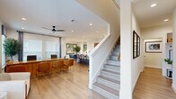 Located in Katy, TX, this well-appointed two-story home offers three bedrooms, four bathrooms, and a dedicated office, all finished with a cohesive modern aesthetic. The main floor hosts the heart of the home — an open-concept living, dining, and kitchen area bathed in natural light from generous windows. The kitchen is a standout, featuring quartz countertops, a large center island with an undermount sink, two-tone cabinetry in white and warm wood tones, stainless steel appliances, and light hardwood-style flooring that flows throughout. The adjacent dining area is elegantly styled, with framed artwork and a marble-top dining table, while the living space is anchored by ceiling fans and recessed lighting. A versatile office on the main floor provides a quiet workspace with ample natural light. Upstairs, the primary bedroom offers a serene retreat with teal accent walls, a ceiling fan, and neighborhood views. Additional bedrooms are bright and well-sized, each with hardwood flooring and tasteful décor. The bathrooms are refined, highlighted by marble-tiled walk-in showers with frameless glass doors and matte black fixtures. A dedicated laundry room with side-by-side washer and dryer completes the upper level. The staircase, finished in light wood with clean white risers, connects both floors with effortless style.