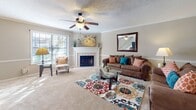 This Monticello model townhome offers a thoughtful layout across two floors, totaling 1220 square feet. The ground floor, measuring 630 square feet, hosts the main living areas. A welcoming entryway leads to a spacious living room, highlighted by a classic fireplace and large windows that flood the space with natural light. The adjacent dining area features hardwood flooring and accommodates a four-seat table, perfect for intimate dinners or entertaining guests.

The kitchen boasts ample wooden cabinetry, providing generous storage. It's equipped with modern appliances and offers sufficient counter space for meal preparation. A convenient powder room completes the ground floor amenities.

Ascending the staircase, the upper level spans 590 square feet and houses the private quarters. The primary bedroom is a generous 230 square feet, offering plenty of space for a large bed and additional furniture. It features an en-suite bathroom and a walk-in closet. The second bedroom is comfortably sized and shares a full bathroom with the hallway.

Throughout the home, neutral wall colors create a bright, airy atmosphere, while crown molding adds a touch of elegance. The property's three full bathrooms are well-appointed with modern fixtures and vanities. This townhome strikes a balance between comfort and functionality, making it an ideal residence for small families or professionals seeking a low-maintenance yet stylish living space.