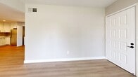 This single-floor residence offers 2 bedrooms and 3 bathrooms within a thoughtfully designed layout. The kitchen is a standout feature, showcasing white shaker-style cabinetry with matte black hardware, quartz countertops, light hardwood flooring, and a full suite of stainless steel appliances including a range, dishwasher, and refrigerator. A convenient in-unit laundry area is tucked behind louvered doors adjacent to the kitchen. The living room is bright and welcoming, featuring large windows with horizontal blinds that frame views of lush greenery and the surrounding neighborhood, filling the space with natural light. Hardwood-style flooring flows through the main living areas, while the bedrooms are finished with plush neutral carpet for added comfort. The primary bedroom is a generously sized retreat with a window overlooking the outdoors. The bathrooms are clean and modern, featuring white vanities with quartz countertops, matte black fixtures, well-lit mirrors, and tub/shower combinations with crisp white surrounds. Neutral warm-toned walls throughout create a cohesive and move-in-ready ambiance, making this a functional and attractive space suitable for a variety of lifestyles.