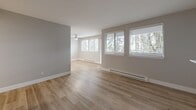 Located at 4117 124th Ave SE in Bellevue, WA, this well-appointed 2-bedroom, 1-bathroom single-floor home offers a thoughtfully designed layout with modern finishes throughout. Light wood-style luxury vinyl plank flooring flows seamlessly across all rooms, complemented by neutral gray tones and crisp white trim that create a clean, contemporary aesthetic.

The open-concept living, dining, and kitchen area serves as the heart of the home. The living room is generously proportioned, featuring multiple windows that frame views of surrounding greenery, flooding the space with natural light. A ceiling fan adds both function and style. The kitchen is well-equipped with white shaker cabinetry, granite countertops, stainless steel appliances including a range, microwave, and refrigerator, a peninsula for additional prep space, and a dedicated pantry for extra storage.

Both bedrooms are comfortably sized, each featuring windows with blinds for natural light and privacy, along with baseboard heating. The spacious primary bedroom includes ample closet space. The full bathroom offers a combined tub and shower, a vanity with storage, and light wood-style flooring consistent with the rest of the home. A private balcony extends the living space outdoors, and multiple closets throughout ensure abundant storage.