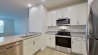 This contemporary 1010 square foot apartment in Allure 2201, Chesapeake, VA, offers a harmonious blend of comfort and functionality. The space boasts two bedrooms, including a generous 230 square foot primary bedroom, and two full bathrooms. The open-concept design creates a seamless flow between the living areas, enhancing the sense of spaciousness.

The kitchen is a highlight, featuring crisp white cabinetry, granite countertops, and stainless steel appliances, including a built-in microwave and a sleek refrigerator. The light-toned wood-look flooring throughout adds warmth and continuity to the space.

Both bedrooms are well-proportioned, with the primary bedroom offering ample space for a king-size bed and additional furniture. Large windows in the bedrooms provide natural light and pleasant views. The bathrooms are modern and functional, with one featuring a spacious vanity with a granite countertop and ample storage.

Storage is not an issue in this apartment, with two closets and additional built-in shelving in the bedrooms. The living room is bright and airy, perfect for relaxation or entertaining. The overall neutral color palette allows for easy personalization.

This single-story apartment combines modern amenities with practical design, creating an ideal living space for those seeking comfort and style in the heart of Chesapeake.