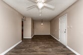 Located at 56 Heery Rd in Newnan, Georgia, this single-floor home offers a practical and comfortable layout with a variety of functional living spaces. The main living area features rich, dark hardwood-style flooring, neutral-toned walls, a ceiling fan, and a set of French doors that allow natural light to fill the room while providing direct access to the outdoors. An adjacent dining area is illuminated by a classic pendant light fixture, creating a defined and welcoming space for meals. The kitchen is efficiently designed in a U-shape configuration, outfitted with warm oak cabinetry, ample counter space, a double sink, and white appliances including a range, built-in microwave, dishwasher, and refrigerator — all finished with matching hardwood-style flooring that ties the space together. The bedrooms are carpeted in a neutral tone, offering a softer underfoot feel, and each is naturally lit by windows with blinds. Ceiling light fixtures are present throughout. Textured ceilings and clean white baseboards are consistent design elements across the home, contributing to a cohesive and tidy aesthetic. The overall layout is straightforward and well-organized, making this Newnan home a functional and inviting living space.
