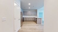 This contemporary apartment in Bethel, CT offers 1050 square feet of thoughtfully designed living space. The open floor plan seamlessly integrates the kitchen and living areas, creating a spacious feel. The kitchen is a highlight, boasting sleek white cabinetry, stainless steel appliances, and ample counter space, perfect for culinary enthusiasts.

Both bathrooms feature elegant marble-look tiling, with one showcasing a luxurious walk-in shower with gold-tone fixtures. The primary bedroom, at 210 square feet, provides a generous retreat. Large windows throughout the apartment flood the spaces with natural light, enhancing the airy ambiance.

The apartment's neutral color palette, dominated by whites and light wood tones, creates a fresh and modern aesthetic. Light wood flooring runs throughout, adding warmth and continuity. High ceilings in some areas further amplify the sense of space.

Storage is well-considered, with ample closet space and additional cabinetry in the kitchen. The overall design emphasizes clean lines and minimalism, resulting in a sleek, contemporary living environment that's both functional and stylish.