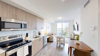 Located on the sixth floor at 1025 E 25th St in Hialeah, Florida, Unit 618 is a thoughtfully designed residence that maximizes its compact footprint with a clean, contemporary aesthetic. Light wood-tone flooring runs throughout, complementing the bright white walls and creating a warm, airy atmosphere.

The open-plan kitchen and living area serves as the heart of the unit. The kitchen features full-height cabinetry in a natural wood finish, a white quartz countertop, and a complete suite of stainless steel appliances, including a refrigerator, electric range, over-the-range microwave, and dishwasher. The adjoining living area is filled with natural light and opens directly onto a private balcony through large sliding glass doors, offering open views of the surrounding Hialeah cityscape.

The bathroom is finished with elegant marble-effect tile on both the walls and the tub surround, paired with a glass-enclosed soaking tub and shower combination. Light concrete-toned flooring and a clean white vanity complete the refined, spa-like feel.

Additional practical features include a dedicated laundry area and a closet, ensuring efficient use of space. The unit's cohesive modern design, abundant natural light, and private outdoor balcony make it a functional and stylish urban residence.