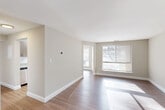 Located at 3900 Greencastle Ridge Dr in Burtonsville, MD, this well-appointed two-bedroom, two-bathroom single-floor residence offers a comfortable and functional layout. The open living area is finished with warm hardwood-style flooring and neutral tones, with large windows that flood the space with natural light and provide pleasant outdoor views. The galley-style kitchen is thoughtfully updated with modern flat-front cabinetry in a warm wood finish, granite-look countertops, a classic white subway tile backsplash, stainless steel appliances including a refrigerator and electric range, and a stainless steel sink — all illuminated by contemporary flush-mount lighting. A bright dining nook at the end of the kitchen benefits from additional window views. The spacious primary bedroom features plush carpeting and generous closet space, including a walk-in closet outfitted with built-in shelving and dual hanging rods. Both bathrooms are finished in a clean, bright palette with wide vanity countertops, large mirrors, and tub-shower combinations with chrome-finish fixtures. Hallways connect the rooms efficiently, and the overall layout makes excellent use of the available space, creating a comfortable and cohesive living environment.