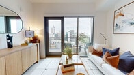 Located in the heart of Midtown Atlanta, this well-appointed 1-bedroom, 2-bathroom residence at 1000 Spring St offers a refined urban living experience with modern finishes throughout. The open-concept living area features large-format tile flooring and floor-to-ceiling sliding glass doors that flood the space with natural light and open to a private balcony showcasing sweeping views of the Atlanta skyline. The kitchen is thoughtfully designed with warm wood-tone cabinetry, under-cabinet lighting, a marble-style quartz countertop, a central island, and a full suite of stainless steel appliances including a gas range and French door refrigerator. The generously sized primary bedroom features light hardwood flooring, a large picture window framing city views, and a ceiling fan, creating a bright and airy retreat. The walk-in closet offers built-in shelving and ample hanging space. The bathroom is finished with marble-style tile flooring, a floating wood vanity, and a large mirror. A dedicated hallway connects all spaces efficiently. The clean, neutral palette and contemporary design details create a cohesive and sophisticated ambiance throughout.