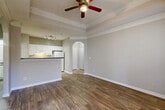 Located at 100 Ardsley Place in Norcross, GA, this one-bedroom, one-bathroom residence offers a well-designed single-floor layout that maximizes both comfort and functionality. The open-concept living, dining, and kitchen area serves as the heart of the home, featuring rich hardwood-style flooring, a tray ceiling with crown molding, and a ceiling fan. Large windows allow generous natural light to fill the space, with a glass door providing direct access to a private balcony. An elegant arched passageway connects the living area to the hallway, adding a refined architectural touch.

The kitchen is outfitted with white raised-panel cabinetry, dark granite-style countertops, a breakfast bar peninsula, and white appliances including a range and refrigerator. A dedicated pantry and track lighting enhance the kitchen's practicality.

The bedroom is a comfortable retreat featuring a tray ceiling with crown molding, a large window with outdoor views, and plush carpeting. It connects to a full bathroom complete with a tub/shower combo with white tile surround, dark countertop vanity, and hardwood-style flooring. Multiple closets—including a spacious walk-in with wire shelving—provide excellent storage throughout. In-unit laundry and a utility room add everyday convenience.