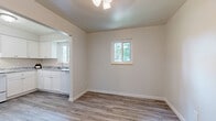 Located at 2925 S Webster St in Denver, Colorado, this single-floor, three-bedroom, two-bathroom home offers a functional and well-organized layout. The interior features a neutral color palette throughout, creating a clean and cohesive aesthetic. Hardwood-style luxury vinyl flooring runs through the main living areas, dining room, kitchen, and bathrooms, while plush carpeting provides comfort in each of the three bedrooms.

The kitchen is outfitted with white shaker-style cabinetry, granite-look countertops, and white appliances including a refrigerator, range, and dishwasher. It opens directly into the dining area, which is brightened by a window overlooking mature trees outside. The living room is spacious and well-lit, completing the main gathering areas.

The bedrooms offer generous proportions, with the primary bedroom featuring a textured ceiling, natural light from a window, and direct access to a closet. Additional bedrooms include ample closet space, some with double-door closets. Nine closets throughout the home provide exceptional storage capacity.

Both bathrooms feature granite-top vanities with white cabinetry, framed mirrors, and hardwood-style flooring. The hallway connects the bedroom wing seamlessly to the rest of the home. This property combines practical storage solutions with a clean, updated interior well-suited to comfortable everyday living.