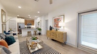 This thoughtfully designed one-bedroom, one-bathroom residence in Leander, TX offers a cohesive open-concept layout with light wood-style flooring flowing through the main living areas. The welcoming entryway features a large window that fills the space with natural light and leads directly into the open living room. The living area is bright and airy, anchored by a ceiling fan overhead and seamlessly connected to the kitchen and dining space. The kitchen is a standout feature, equipped with stainless steel appliances including a side-by-side refrigerator, microwave, and range, complemented by warm wood cabinetry, a tile backsplash, and a granite-topped island with bar seating—ideal for casual dining and entertaining. A hallway connects the main living area to the private bedroom, which is carpeted for comfort and features a window with natural light, a closet, and direct access to the full bathroom. The bathroom is well-appointed with a wood vanity cabinet, granite countertop, and an illuminated mirror. The space also includes a dedicated closet for additional storage. Clean white walls and recessed lighting throughout create a bright, modern ambiance well-suited for comfortable everyday living.