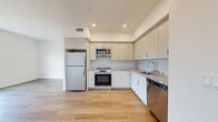 Located at 18900 Parthenia St in Los Angeles, CA, this modern 3-bedroom, 2-bathroom unit offers a thoughtfully designed single-floor layout. The open-concept living and kitchen area is bright and airy, anchored by wide-plank wood-look flooring that flows seamlessly throughout the space. The kitchen is outfitted with stainless steel appliances, including a refrigerator, range, and microwave, complemented by gray shaker cabinetry, granite-style countertops, and a classic subway tile backsplash. Large windows in the living area invite abundant natural light and offer views of the surrounding neighborhood. The three bedrooms are clean and well-proportioned, with the primary bedroom featuring access to a private balcony with outdoor views. Each bedroom benefits from the same warm wood-look flooring and crisp white walls. Both bathrooms are finished with marble-style tiled tub-shower combinations, granite-top vanities, and light tile flooring, with one bathroom featuring an LED-backlit mirror for a contemporary touch. The overall design aesthetic is clean and modern, with a neutral color palette that creates a calm, cohesive ambiance throughout the home.