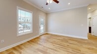 Located on Old Lovers Lane in Bowling Green, Kentucky, this single-floor, 2-bedroom, 2-bathroom home offers a clean, modern design with consistent light wood flooring throughout. The living area is bright and welcoming, featuring crown molding, a ceiling fan, recessed lighting, and a glass-panel door that invites natural light from the surrounding neighborhood. The kitchen is well-equipped with rich dark-mahogany cabinetry, granite countertops, a peninsula with a built-in sink, and a full suite of stainless steel appliances including a refrigerator, range, and over-the-range microwave. The primary bedroom is comfortably sized, with a ceiling fan and a large window fitted with horizontal blinds offering views of the neighborhood. The second bedroom also features a ceiling fan, ample natural light, and the same warm wood flooring. Both bathrooms are finished with matching dark-wood vanities, granite countertops, and clean white fixtures. One bathroom includes a walk-in shower with built-in shelving. The home also includes a hallway and a dedicated closet for additional storage. Neutral warm-beige walls and crisp white trim create a cohesive, move-in-ready aesthetic throughout the entire space.