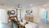 Located in Lake Charles, Louisiana, this thoughtfully designed 4-bedroom, 3-bathroom home offers a functional and stylish single-floor layout. The open-concept kitchen and dining area serves as the heart of the home, showcasing gray shaker-style cabinetry, granite countertops, a large center island with seating, pendant lighting, and a full suite of stainless steel appliances. Polished concrete floors flow throughout the main living areas, lending a modern, low-maintenance aesthetic. The living room is bright and welcoming, featuring a ceiling fan, recessed lighting, wainscoting details, and access to a private balcony. The dining space benefits from natural light streaming through large windows dressed with decorative curtains. Each of the four bedrooms is well-proportioned, with the primary bedroom offering dedicated closet space and natural light. With seven closets total, storage is abundant throughout. The three bathrooms are finished with granite-topped vanities and gray cabinetry consistent with the home's overall design palette. A dedicated laundry room and a central hallway complete the layout, making this home as practical as it is polished.