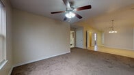 Located at 211 Olympus Dr in Bull Creek, Missouri, this single-floor home offers a well-organized layout with comfortable living spaces throughout. The open living and dining area features plush carpeting, neutral-toned walls, and ceiling fans with integrated lighting, creating a bright and functional environment. A pendant chandelier adds a touch of elegance to the dining space, which transitions smoothly into adjacent rooms. The kitchen is equipped with rich dark wood cabinetry, ample counter space, tile flooring, and white appliances including a range, microwave, dishwasher, and refrigerator. Multiple bedrooms are carpeted and well-lit, each featuring ceiling fans and windows with blinds that allow natural light while maintaining privacy. Closet access is available in the bedrooms, providing practical storage solutions. The home includes two bathrooms: one with a tub/shower combination, dark wood vanity, and tile flooring, and a second featuring a walk-in shower stall with a grab bar, matching cabinetry, and tile flooring. Throughout the home, consistent neutral wall tones and white trim provide a clean, cohesive aesthetic that is move-in ready and adaptable to a variety of interior styles.