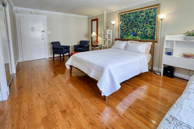 Dormitorio principal con cama y zona de estar. - 1420 N St NW