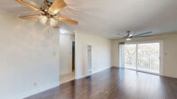 Located in the Glassell Park neighborhood of Los Angeles, this 2-bedroom, 1-bathroom residence offers a well-organized single-floor layout with a comfortable, functional design throughout. The open living room flows directly into the kitchen and features rich dark hardwood flooring, crown molding, ceiling fans, and sliding glass doors that lead to a private balcony with views of the surrounding greenery, filling the space with natural light. The kitchen is equipped with white cabinetry, dark granite-style countertops, a gas range, built-in microwave, refrigerator, and a sink beneath additional upper cabinets — all tied together with matching hardwood flooring. Both bedrooms are carpeted and feature ceiling fans, crown molding, and generous closet space with mirrored sliding doors. The primary bedroom includes a wall-mounted air conditioning unit and a bright window. The full bathroom has been tastefully updated with large-format marble-look tile surrounding a full soaking tub with a glass sliding shower enclosure and a dark granite vanity. The unit also includes a hallway connecting the rooms, three closets for ample storage, and a balcony ideal for outdoor relaxation.