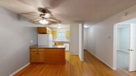 Located at 11200 SW Greenburg Rd in Tigard, Oregon, this single-floor, three-bedroom, one-bathroom unit offers a practical and well-organized layout. A welcoming hallway with warm hardwood-style flooring leads into the main living areas. The living room is carpeted and filled with natural light, anchored by a sliding glass door that opens to a private outdoor patio with a wood-railed fence. The kitchen is efficiently designed with warm honey-toned wood cabinetry, granite-style countertops, a peninsula with additional counter space, and white appliances including a refrigerator, range, and dishwasher. A ceiling fan with light fixture and a window over the sink add both function and brightness. The three bedrooms are carpeted and feature textured ceilings, neutral walls, and windows with blinds that bring in natural light. The primary bedroom offers a comfortable footprint with closet access. The bathroom is appointed with a rich wood vanity, granite countertop, a mirrored medicine cabinet with overhead lighting, and a clean, functional design. Throughout the unit, textured ceilings and clean white trim provide a consistent, tidy finish.
