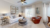 Located in Sugar Land, TX, this single-story 2-bedroom, 2-bathroom home offers a thoughtfully designed layout with modern finishes throughout. The galley-style kitchen is equipped with stainless steel appliances, white shaker cabinetry, and granite countertops, flowing into a peninsula with bar seating and pendant lighting — ideal for casual dining or entertaining. The living room features crown molding, a ceiling fan, wood-look flooring, and a large window that fills the space with natural light. The adjacent dining area continues the bright aesthetic with tall windows dressed in sheer curtains. Both bedrooms are carpeted and comfortable; the primary bedroom includes a vaulted ceiling with a ceiling fan, offering a sense of added openness. Both bathrooms are finished with marble-look tile surrounds, soaking tub-shower combos, granite vanity tops, and white cabinetry with brushed hardware. A hallway connects the rooms efficiently, keeping the layout cohesive. The overall palette is neutral and light throughout, with soft grays and whites creating a clean, modern ambiance well-suited to everyday living.
