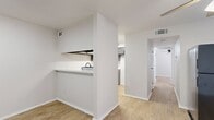 This 2-bedroom, 1-bathroom residence offers a clean, modern aesthetic anchored by light wood-style flooring that flows consistently throughout the entire unit. The layout is thoughtfully organized, connecting a combined dining and living area to a kitchen defined by its practical pass-through design. The kitchen is well-appointed with gray shaker-style cabinetry, matte black hardware, stone-look countertops, a stainless steel sink, and a black dishwasher — providing both style and function. A hallway connects the main living areas to the private quarters, where two bedrooms each feature ceiling fans with integrated lighting and ample natural light through window blinds. The primary bedroom includes a closet, while additional closet space serves the rest of the unit, totaling three closets throughout. The bathroom is outfitted with a full tub-and-shower combination, accented by matte black fixtures and a clean white surround. Crisp white walls and consistent trim work throughout give the space a bright, cohesive feel. The single-floor layout ensures easy navigation, and the efficient use of space makes this residence feel comfortable and practical.