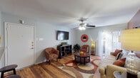Located at 5500 S Hulen St in Fort Worth, Texas, this single-floor residence offers a thoughtfully designed layout that balances comfort and functionality. The living room serves as the heart of the home, showcasing rich hardwood flooring, a bold terracotta accent wall, and a ceiling fan that adds to the welcoming ambiance. Large vertical-blind sliding doors flood the space with natural light and provide access to a private patio. A dedicated dining area adjacent to the living room features a pendant light fixture and warm-toned accent wall, creating an intimate setting for meals. The galley-style kitchen is efficiently organized with warm wood cabinetry, a tile backsplash, granite-style countertops, and black appliances, including a range and refrigerator. A pass-through connects the kitchen to a laundry area for added convenience. The bedroom offers a serene retreat with soft carpeting, a ceiling fan, a large closet with built-in organization, and a window dressed with elegant draping that lets in gentle natural light. The bathroom is clean and functional, featuring a tiled shower-tub combination. Throughout, the residence presents a cohesive, warm aesthetic suited for comfortable everyday living.