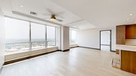 Located in the heart of downtown Dallas at 1403 Main St, this sophisticated 2-bedroom, 2-bathroom residence delivers a refined urban living experience with thoughtful design throughout. The open-plan kitchen and living area serves as the centerpiece of the home, featuring light hardwood flooring, a tray ceiling with recessed lighting, and expansive floor-to-ceiling windows that frame sweeping city views. The kitchen is outfitted with rich wood cabinetry, stainless steel appliances, a built-in microwave, and light stone countertops extending to a peninsula — ideal for both cooking and entertaining. The generously sized primary bedroom is carpeted for comfort and bathed in natural light through large windows overlooking the Dallas skyline. Its en-suite bathroom features large-format tile flooring, a glass-enclosed walk-in shower with marble-style tile surround, and clean modern fixtures. The second bedroom is equally well-appointed with a ceiling fan and its own adjacent full bathroom, complete with a soaking tub and tiled shower surround. Both bedrooms include dedicated closets with built-in shelving. A separate laundry room houses a full-size washer and dryer. The residence combines contemporary finishes with abundant natural light and striking urban views throughout.