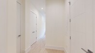 Located at 812 W Adams St in Chicago's vibrant West Loop neighborhood, this modern one-bedroom, one-bathroom residence offers a thoughtfully designed open-concept layout across a single floor. Light hardwood flooring flows throughout the unit, complementing a clean, contemporary aesthetic defined by crisp white walls and recessed lighting.

The living and dining area is anchored by expansive floor-to-ceiling windows that flood the space with natural light and frame dynamic city views of the surrounding Chicago skyline. The kitchen features sleek white cabinetry extending to the ceiling, a marble-toned countertop, stainless steel appliances including a gas range and microwave, and a peninsula that doubles as a casual dining surface — all illuminated by a modern pendant light fixture.

A welcoming hallway connects the main living space to the private quarters, lined with clean white panel doors and ample built-in storage. The bedroom is a serene retreat with recessed lighting, a large sliding-door closet, and light hardwood floors. The bathroom is finished with a contemporary floating vanity, white quartz countertop, undermount sink with a chrome faucet, a large mirror, and elegant tiled walls. The overall ambiance is bright, minimalist, and polished — ideal for urban living.