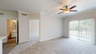 Located at 4807 Pin Oak Park in Houston, TX, this single-floor, one-bedroom, one-bathroom unit offers a functional and comfortable layout. The living room is bright and open, featuring plush carpeting, crown molding, a ceiling fan with light fixture, and sliding glass door access to a patio that brings in generous natural light. A decorative pendant light accents the entryway, which transitions from tile to carpet flooring.

The kitchen is well-equipped with white cabinetry, light-toned countertops, and stainless steel appliances including a refrigerator and range. A peninsula with a double sink and breakfast bar connects the kitchen to the living area, with light wood-look flooring running throughout the kitchen space.

The bedroom is a comfortable size, finished with soft carpeting, crown molding, a ceiling fan, and a window with outdoor views. A dedicated walk-in closet with built-in shelving and hanging rods provides ample storage. An additional closet is also present.

The bathroom features a full tub-shower combination with white tile surround and wood-look flooring. A separate laundry area adds everyday convenience. The unit's neutral color palette and consistent finishes create a clean, cohesive atmosphere throughout.
