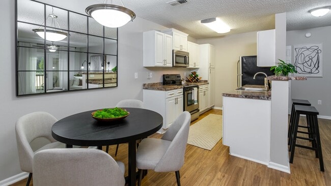 From meal prep to dinner parties, this open-concept kitchen and dining area offers both functionality and style with a spacious layout and contemporary design. - Grand Oaks At The Lake