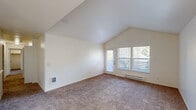 Located at 4505 SW Masters Loop in Beaverton, Oregon, this single-story, 3-bedroom, 2-bathroom home offers a well-organized layout across a comfortable footprint. The living room is a standout feature, boasting soaring vaulted ceilings that create an open, airy atmosphere, plush carpet flooring, and a sliding glass door flanked by large windows that flood the space with natural light and provide outdoor views. A baseboard heating system runs along the exterior walls throughout the home.

The galley-style kitchen is efficiently designed with ample white cabinetry trimmed in warm wood tones, light countertops, wood-look vinyl flooring, and white appliances including a range and refrigerator. Adjacent to the kitchen is a dining area with a ceiling fan and an additional window for natural light.

Each of the three bedrooms features carpet flooring, vaulted or standard ceilings, natural light from windows with vertical blinds, baseboard heating, and closet storage. The primary bedroom is generously sized with its own dedicated closet space.

Both bathrooms are finished with wood-look vinyl flooring, white vanity cabinetry, light countertops, and a bathtub-shower combination. A hallway connects the main living areas to the bedrooms and bathrooms. A dedicated in-unit laundry closet with side-by-side washer and dryer hookups adds a practical convenience to this functional home.