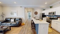 Located at 625 U.S. 29 in Athens, GA, this single-floor, 2-bedroom, 2-bathroom residence offers a thoughtfully designed open-concept layout that maximizes functionality and flow. Wood-look flooring runs throughout, tying each space together with a warm, cohesive aesthetic.

The combined kitchen and living area serves as the heart of the home. The kitchen is outfitted with crisp white shaker cabinets, a striking blue shiplap island with bar seating, stainless steel appliances, a subway tile backsplash, and crown molding accents. Recessed lighting brightens the space, which opens seamlessly into the living area — a comfortable retreat featuring a wall-mounted TV, access to a private exterior door, and ample natural light.

A central hallway connects the two bedrooms and bathrooms. The primary bedroom offers a serene atmosphere with natural light from a window, neutral tones, and hardwood-style flooring. The second bedroom is equally well-lit and inviting. Both bathrooms are finished with white cabinetry and wood-look flooring, providing a clean, modern feel. A dedicated closet adds practical storage. The overall ambiance is modern, bright, and move-in ready — ideal for comfortable everyday living in Athens.